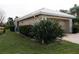 Tan house with white roof, double-car garage, and tropical landscaping at 326 Saint George Ct # 14, Venice, FL 34293