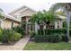 Tan house with white roof, double wood doors, and neatly landscaped yard at 326 Saint George Ct # 14, Venice, FL 34293