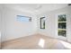 Bright bedroom with a ceiling fan, and light wood flooring complemented by natural light from the windows and glass door at 2111 Hawthorne St, Sarasota, FL 34239