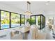 Bright dining room featuring a modern chandelier, views of the pool, and glass doors to the outdoor space at 2111 Hawthorne St, Sarasota, FL 34239