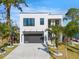 Modern two-story home with white exterior, black framed windows, and a well-maintained lawn with palm trees at 2111 Hawthorne St, Sarasota, FL 34239