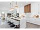 Modern kitchen with white cabinetry, a large island with seating, pendant lighting, and stainless steel appliances at 2111 Hawthorne St, Sarasota, FL 34239