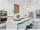 Modern kitchen featuring a large island with seating, white cabinetry, pendant lighting, and stainless steel appliances at 2111 Hawthorne St, Sarasota, FL 34239