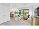 Open-concept living room with neutral décor, tile floors, modern furnishings and access to the backyard at 2111 Hawthorne St, Sarasota, FL 34239