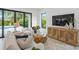 Living room featuring modern decor, plush seating, a contemporary entertainment center, and backyard views at 2111 Hawthorne St, Sarasota, FL 34239