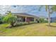 Landscaped backyard with view of home's back and screened patio at 12327 Thornhill Ct, Lakewood Ranch, FL 34202