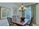 Formal dining area with wood table, chandelier, and green and beige curtains at 12327 Thornhill Ct, Lakewood Ranch, FL 34202