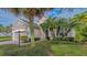Tan house with a dark gray front door, palm trees, and well-manicured landscaping at 12327 Thornhill Ct, Lakewood Ranch, FL 34202