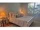 Cozy bedroom with a comfortable bed, soft lighting, and a view of the outdoors at 909 Barclay Ct, Venice, FL 34293