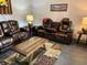 Living room with brown leather reclining sofas and a coffee table at 10469 Waterbird Way, Bradenton, FL 34209