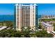 Aerial view of a luxury highrise building with waterfront views and lush landscaping at 340 S Palm Ave # 15, Sarasota, FL 34236