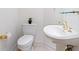 Small bathroom with pedestal sink, toilet, and gold fixtures at 340 S Palm Ave # 15, Sarasota, FL 34236