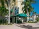 Building entrance with a green awning, stairs, and landscaping at 340 S Palm Ave # 15, Sarasota, FL 34236