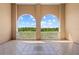 Spacious balcony with stone flooring and archway overlooking lush greenery and blue skies at 7710 Lake Vista Ct # 404, Lakewood Ranch, FL 34202