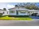 Front view of a single story home with carport and well-manicured lawn at 6033 Arlene Way # 3, Bradenton, FL 34207