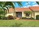 Front view of house with tile roof and lush landscaping at 328 Eden Dr, Englewood, FL 34223