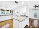 White kitchen features granite countertops, stainless steel appliances, and wood floors at 107 Los Cedros Dr, Anna Maria, FL 34216