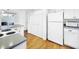 Kitchen boasts white cabinets, granite counters, and wood floors at 107 Los Cedros Dr, Anna Maria, FL 34216