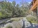 Landscaped yard with mature trees and a gravel pathway at 107 Los Cedros Dr, Anna Maria, FL 34216