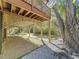Large shaded area under the house with gravel and a tree nearby at 107 Los Cedros Dr, Anna Maria, FL 34216