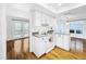 White kitchen with hardwood floors and view to living room at 107 Los Cedros Dr, Anna Maria, FL 34216
