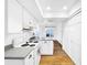 Eat-in kitchen with white cabinets, granite counters, and wood floors at 107 Los Cedros Dr, Anna Maria, FL 34216