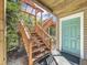 Wooden stairs leading up to an elevated home with a teal door at 107 Los Cedros Dr, Anna Maria, FL 34216