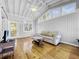 Bright sunroom with vaulted ceilings, hardwood floors, and access to a deck at 107 Los Cedros Dr, Anna Maria, FL 34216