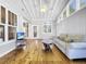 Bright sunroom with vaulted ceilings, hardwood floors, and access to a deck at 107 Los Cedros Dr, Anna Maria, FL 34216
