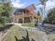 Elevated home with large deck, pergola and lush landscaping at 107 Los Cedros Dr, Anna Maria, FL 34216