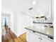 Bright eat-in kitchen with white cabinets, granite countertops, and wood floors at 107 Los Cedros Dr, Anna Maria, FL 34216