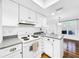 White kitchen with granite countertops and stainless steel appliances at 107 Los Cedros Dr, Anna Maria, FL 34216