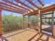 Covered deck with pergola, wooden railings, and scenic wooded views at 107 Los Cedros Dr, Anna Maria, FL 34216