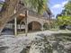 Elevated home with deck and large shaded area underneath, next to a bench at 107 Los Cedros Dr, Anna Maria, FL 34216
