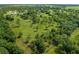 Aerial view showing a large parcel of land with surrounding trees and a home in the distance at 34452 Singletary Rd, Myakka City, FL 34251