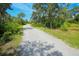 Long gravel driveway through a wooded area at 34452 Singletary Rd, Myakka City, FL 34251