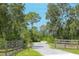 Gravel driveway entrance with wooden fence and No Trespassing sign at 34452 Singletary Rd, Myakka City, FL 34251