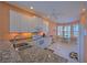 Modern kitchen boasts granite countertops, white cabinets, and stainless steel appliances at 8146 Stirling Falls Cir, Sarasota, FL 34243