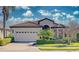 One-story house with beige exterior, a three-car garage, and tropical landscaping at 8146 Stirling Falls Cir, Sarasota, FL 34243