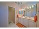 Double vanity bathroom with orange accents and tiled floors at 8146 Stirling Falls Cir, Sarasota, FL 34243