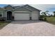 Two-car garage and paver driveway with a neutral-colored exterior at 2275 Hamburg Ln, Punta Gorda, FL 33983