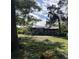 Large backyard with a wooden fence and overgrown landscaping at 38 Old Venice Rd, Osprey, FL 34229