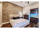 Bedroom with brick accent wall, tufted headboard, and dark wood furniture at 20910 Parkstone Ter, Bradenton, FL 34202