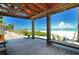 Charming covered wooden deck providing shade and a picturesque view of the sandy beach and turquoise ocean at 7909 20Th W Pl, Bradenton, FL 34209