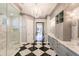 Luxurious bathroom with a black and white checkered floor, double vanity and a walk in shower at 20910 Parkstone Ter, Bradenton, FL 34202