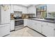 Full view of condo kitchen with white cabinets and stainless steel appliances at 1400 Barcarrota Blvd W # 201, Bradenton, FL 34205