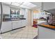 Condo kitchen with white cabinets, tile backsplash, and stainless steel appliances at 1400 Barcarrota Blvd W # 201, Bradenton, FL 34205