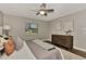 Well-lit bedroom with ceiling fan, dresser, soft rug, and a large window for plenty of natural light at 4512 Ulster Ave, North Port, FL 34287