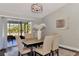 Dining room with sliding glass doors to a screened-in patio with a view of the landscaped backyard at 4512 Ulster Ave, North Port, FL 34287