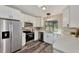 Well-lit kitchen featuring modern white cabinets, stainless steel appliances, and dark hardware at 4512 Ulster Ave, North Port, FL 34287